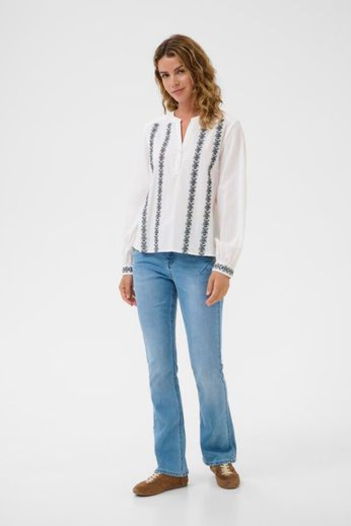 Cotton blouse with embroidery. It has a V-neck and a loose, comfortable fit.