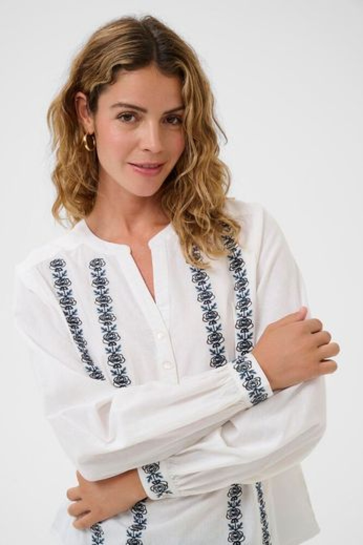 Cotton blouse with embroidery. It has a V-neck and a loose, comfortable fit.