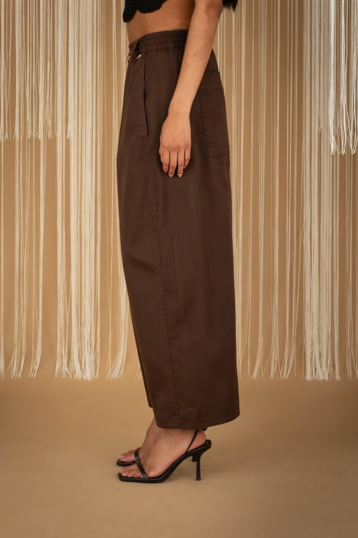 Wide-leg pants with elastic waist, available in black and ecru.