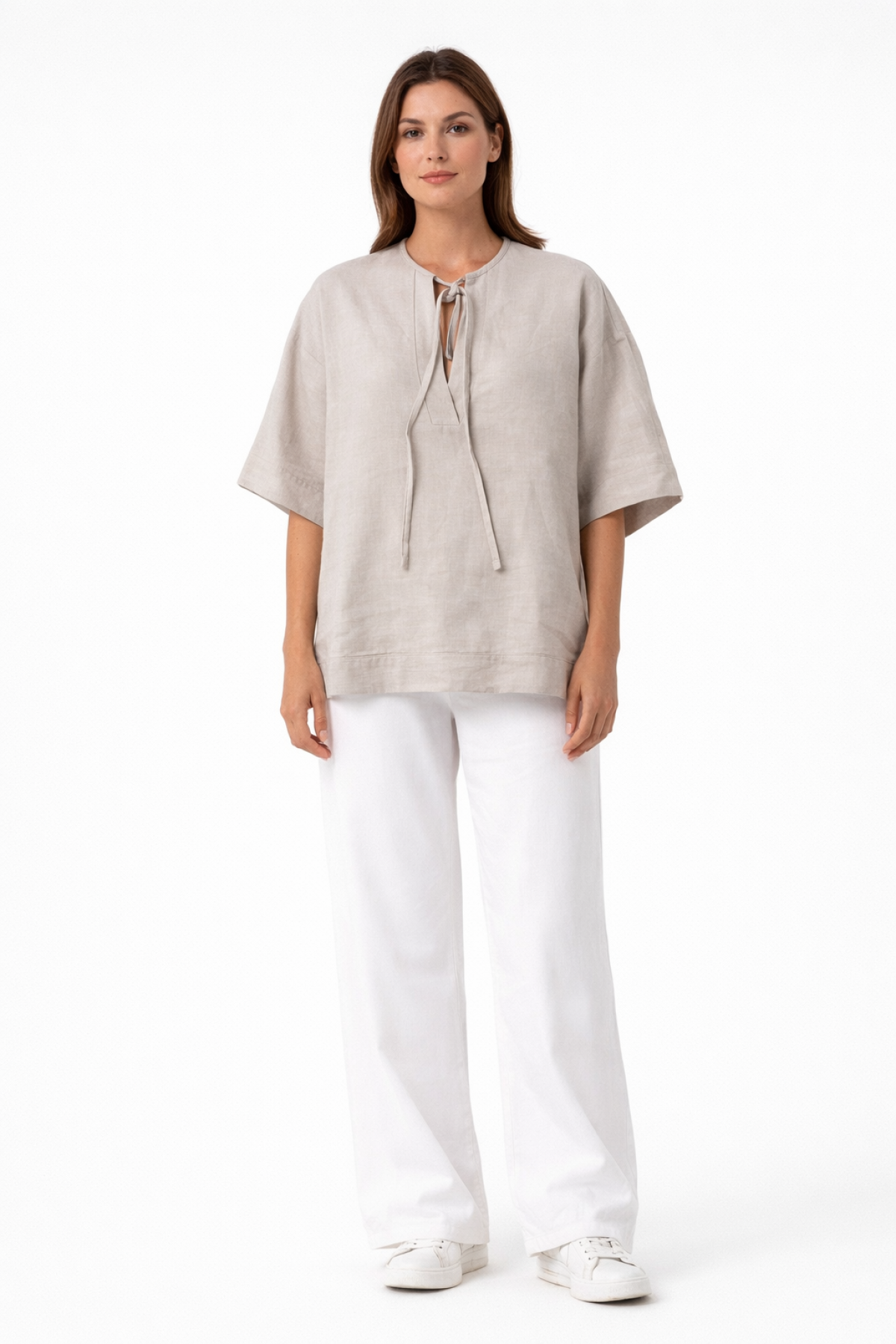 Relaxed blouse with wide sleeves, a round neckline, and a subtle front opening with tie strings.