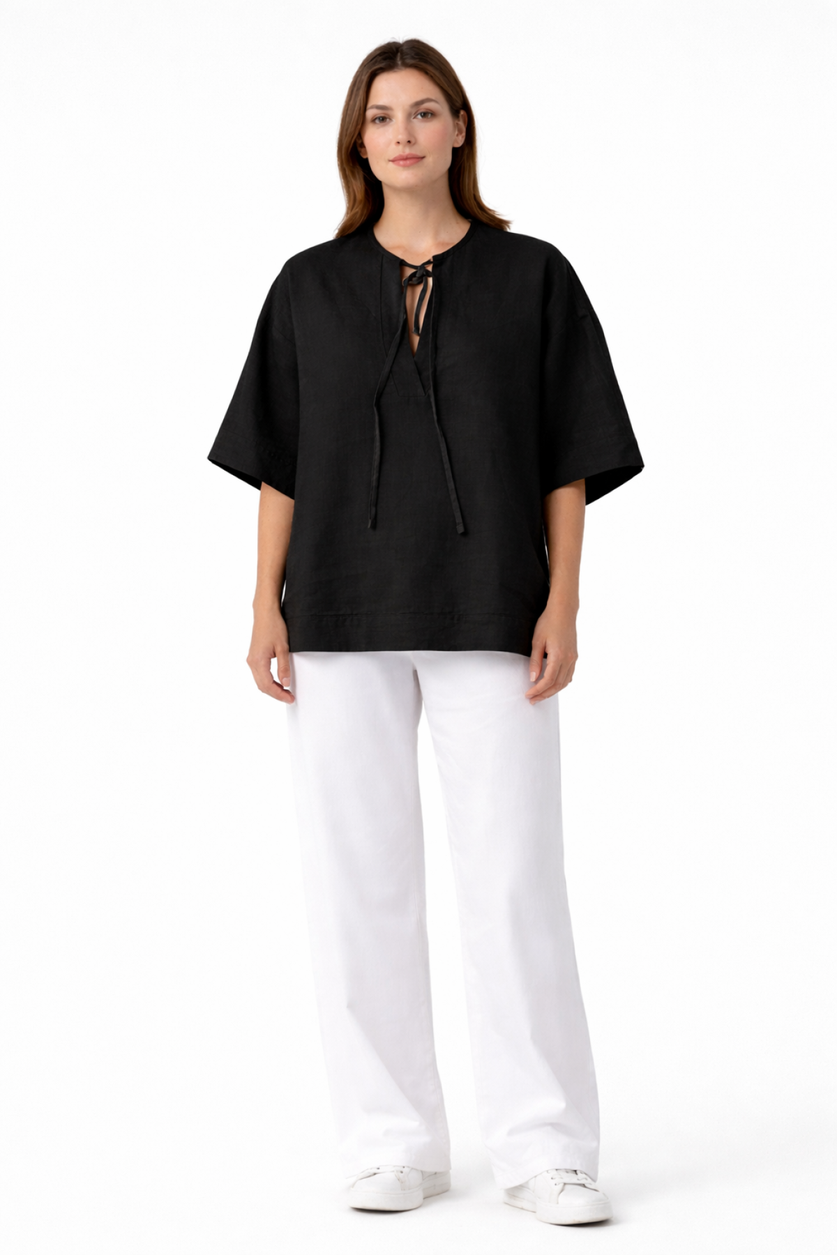 Relaxed blouse with wide sleeves, a round neckline, and a subtle front opening with tie strings.