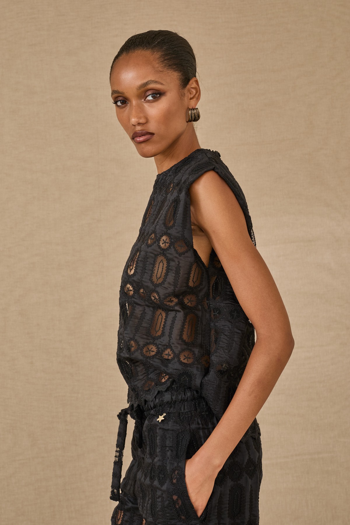 Μαύρο τoπ με ανάγλυφα σχέδια, συνδύασε το και με την παντελόνα  από την ίδια συλλογή